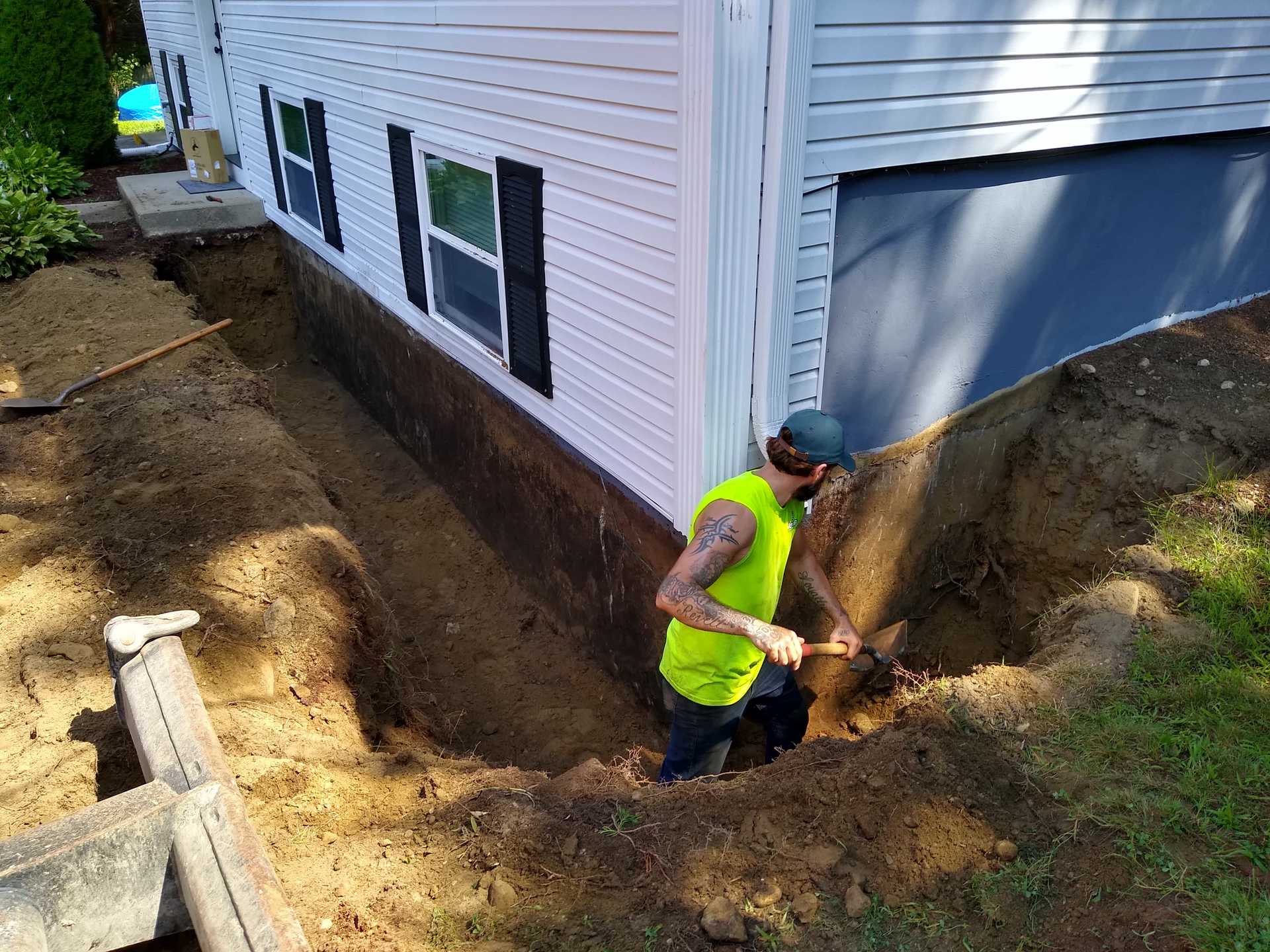 Hunter Environmental worker digging around a house